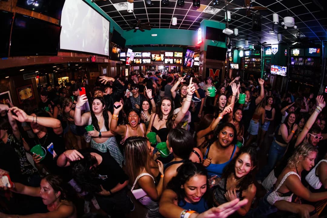A packed crowd with hands up at a charity event